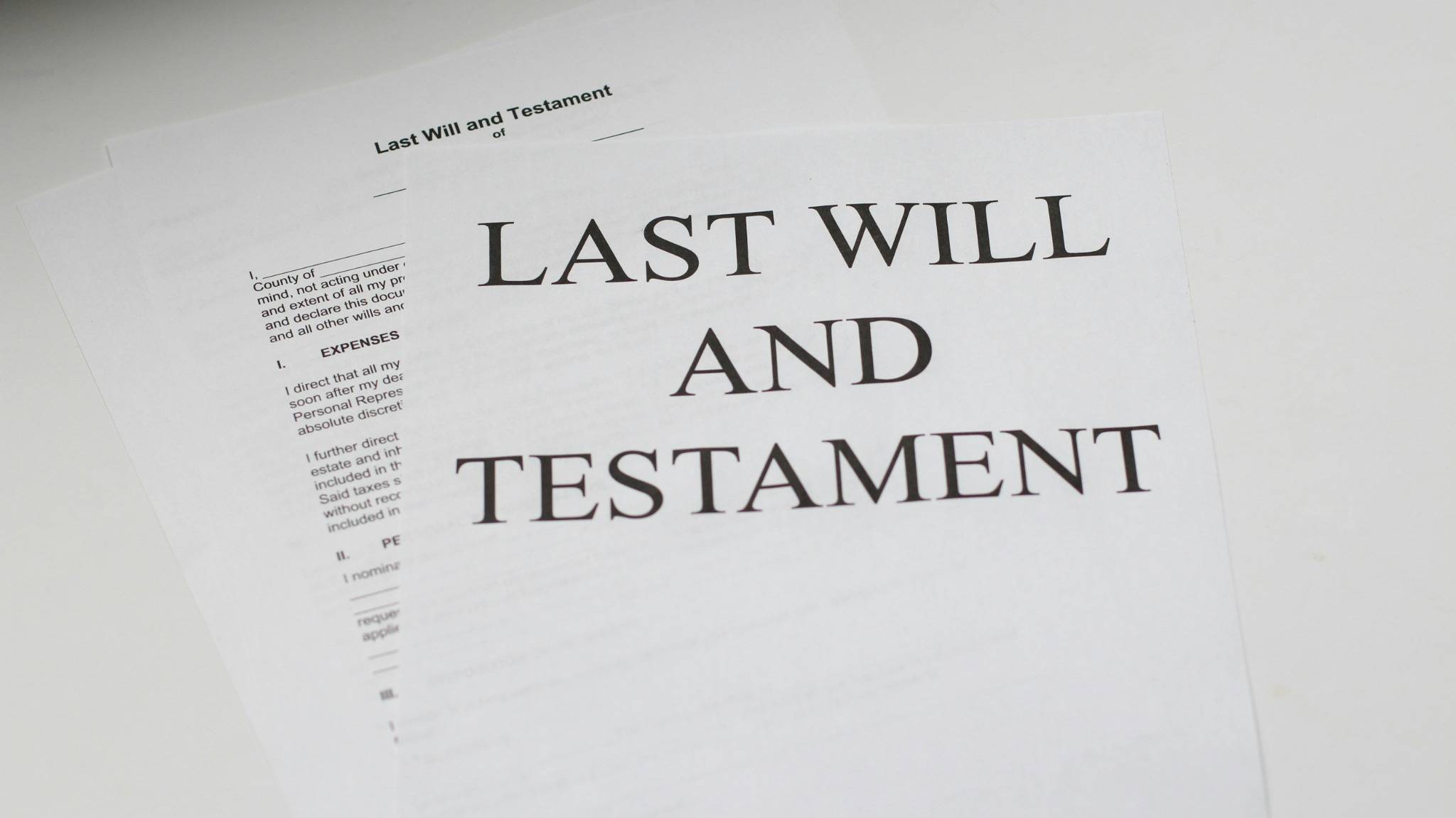 Printed Last Will and Testament documents placed on a white surface, representing estate planning services.